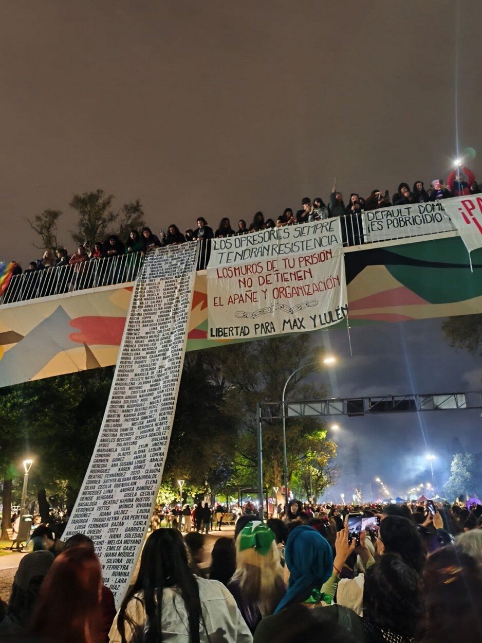 Desde una pasarela, una bandera con cientos de nombres de víctimas de la violencia de género cayó sobre la multitud.
