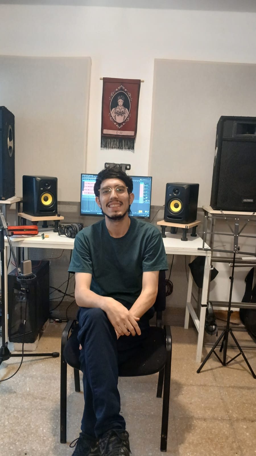 Fer Cruza sentado en su estudio de grabación, frente a los monitores y la computadora.